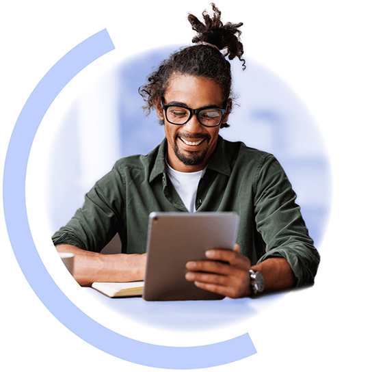 A man looking at a book and a tablet